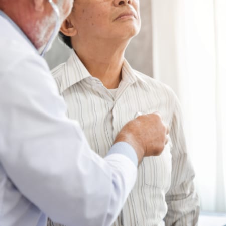 A doctor in a white coat uses a stethoscope to examine a patient in a striped shirt who looks upward, suggesting a checkup.